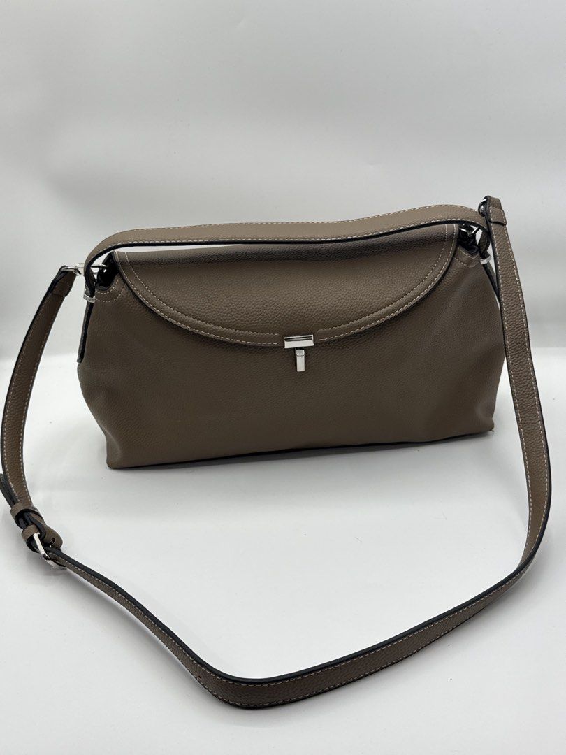 Toteme bag (Category: Cross-body Bags) located in Caloocan City. Submitted by rossvault2 (Listing ID 1465228857, Image 1). Description: - Brand: Toteme - Model: T-Lock Clutch - Color: Taupe - Material: Grained leather with clean texture - Hardware: Silver-tone with engraved logo - Closure: Structured flap with twist-lock - Details: Contrast edge stitching, Made in Italy stamp inside - Strap: Adjustable and removable shoulder strap with metal ring