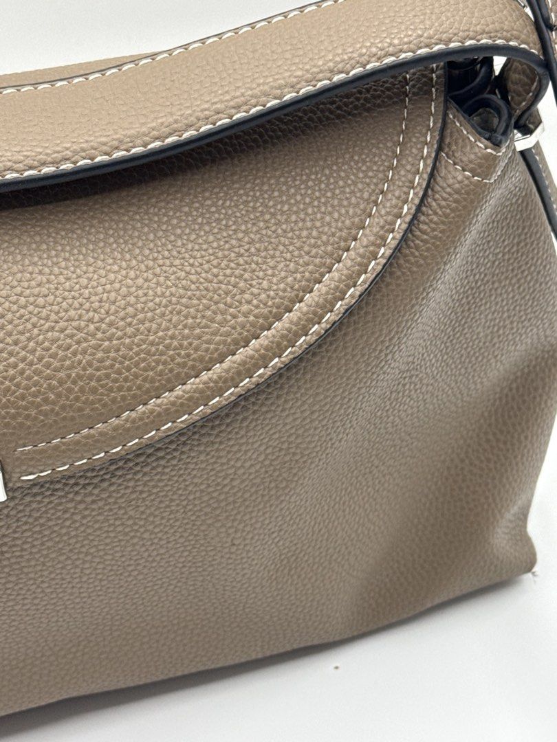 Toteme bag (Category: Cross-body Bags) located in Caloocan City. Submitted by rossvault2 (Listing ID 1465228857, Image 2). Description: - Brand: Toteme - Model: T-Lock Clutch - Color: Taupe - Material: Grained leather with clean texture - Hardware: Silver-tone with engraved logo - Closure: Structured flap with twist-lock - Details: Contrast edge stitching, Made in Italy stamp inside - Strap: Adjustable and removable shoulder strap with metal ring
