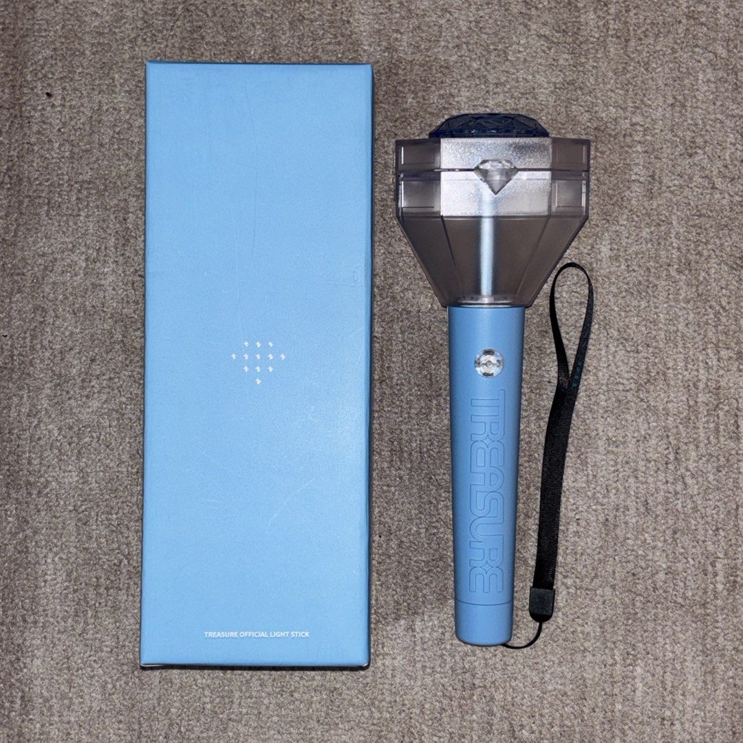 TREASURE Official Light Stick (Category: K-Wave Merchandise) located in San Mateo. Submitted by shop_with_lau (Listing ID 1465260517, Image 1). Description: - Official TREASURE light stick - Includes original light blue box with silver diamond logo - Light blue handle with embossed lettering and transparent head with inner diamond - Comes with a black wrist strap - Perfect for concerts and fan meetings.