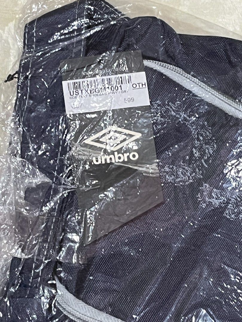 Umbro Side Text Shoe Bag Navy (Category: Sling Bags) located in Dasmarinas. Submitted by gmxngmmd (Listing ID 1465360171, Image 3). Description: Umbro Shoe Bag - Authentic Umbro shoe bag in classic navy blue - Brand new and untouched, still sealed in original plastic packaging - Original store tag attached - Stylish white piping details along the front zipper - Features the iconic Umbro logo near the bottom.