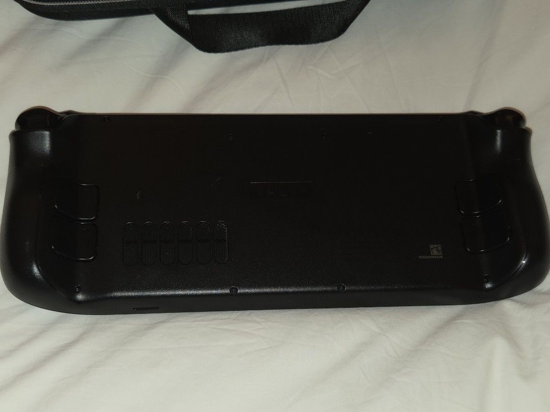 Valve Steam Deck Handheld Console with Case （分類：其他）位於 Hong Kong。 由 patrickmul90661 提交（商品編號 1465296860，圖片 3）。簡介： Valve Steam Deck handheld gaming console in matte black. Original zipper carrying case included with zip pulls and red Steam logo tag. Dual trackpads, thumbsticks, and grip buttons layout. Rear air vents and Valve logo molded on the back casing. Portable gaming setup ready to go. Steamdeck is really good in my opinion, only selling as I