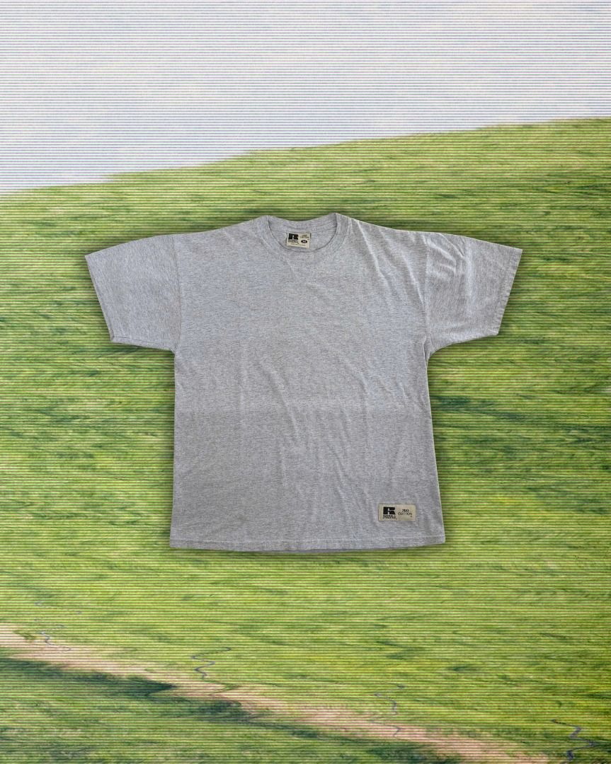 Vintage 1990s RUSSELL ATHLETIC Blank Tee (Category: Tshirts & Polo Shirts ) located in Cebu City. Submitted by threadless.vtg (Listing ID 1465335557, Image 1). Description: Vintage 1990s RUSSELL ATHLETIC Blank Tee Tag: Russell Athletic Size: M Color: Gray (color may vary due to lighting) Condition: Good Measurements: 21" W × 26.5" L Issue: Minor stains near bottom hem PHP 400 🚚 Free nationwide shipping Bulk orders may require additional shipping