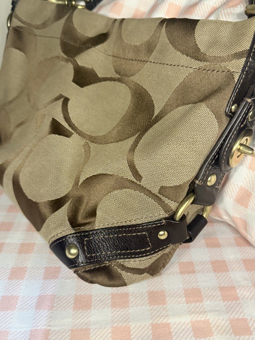 Vintage Coach Carly Medium (Category: Luxury Bags & Wallets) located in Cavite. Submitted by yumicutie03 (Listing ID 1465282177, Image 2). Description: - Authentic brown canvas Coach handbag with signature C monogram - Dark brown leather trim with chic stud accents at the corners - Brass-tone hardware and signature leather hangtag - Structured shoulder strap with durable metal clip hardware - Clean interior lining featuring a convenient zip pocke