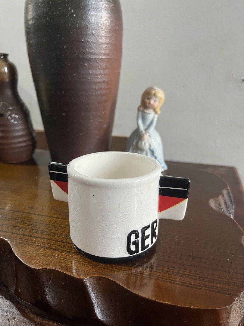 Vintage German Flag Ceramic Small Mug (Category: Coffee & Tea Tableware) located in Taguig. Submitted by minmin_parker (Listing ID 1465233123, Image 1). Description: - Small ceramic mug with a unique crackle glaze finish - Features 'GER' lettering and a sleek black base trim - Handle tabs painted in the German flag colors (black, red, and yellow) - Sits flat and stable on any surface - Great addition to any mug collection or display.