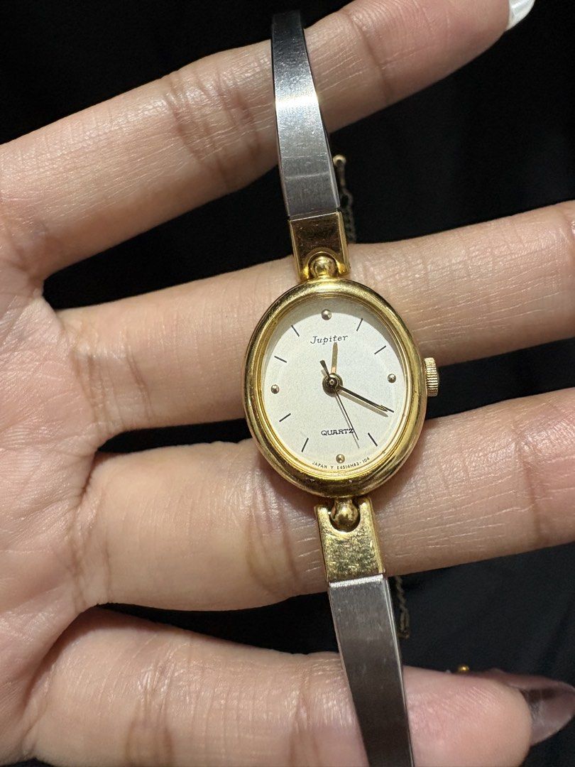 Orient Jupiter Quartz Oval Bangle Watch Two-Tone (Category: Women's Watches) located in Caloocan City. Submitted by esnairahhh (Listing ID 1465378316, Image 2). Description: - Brand/Model: Jupiter oval face wristwatch - Band: Two-tone metal bracelet in silver and gold - Dial: White face with dark baton markers and hands - Movement: Classic quartz movement (marked Japan) - Features: Right-side crown for time adjustment and a secure safety chain ne
