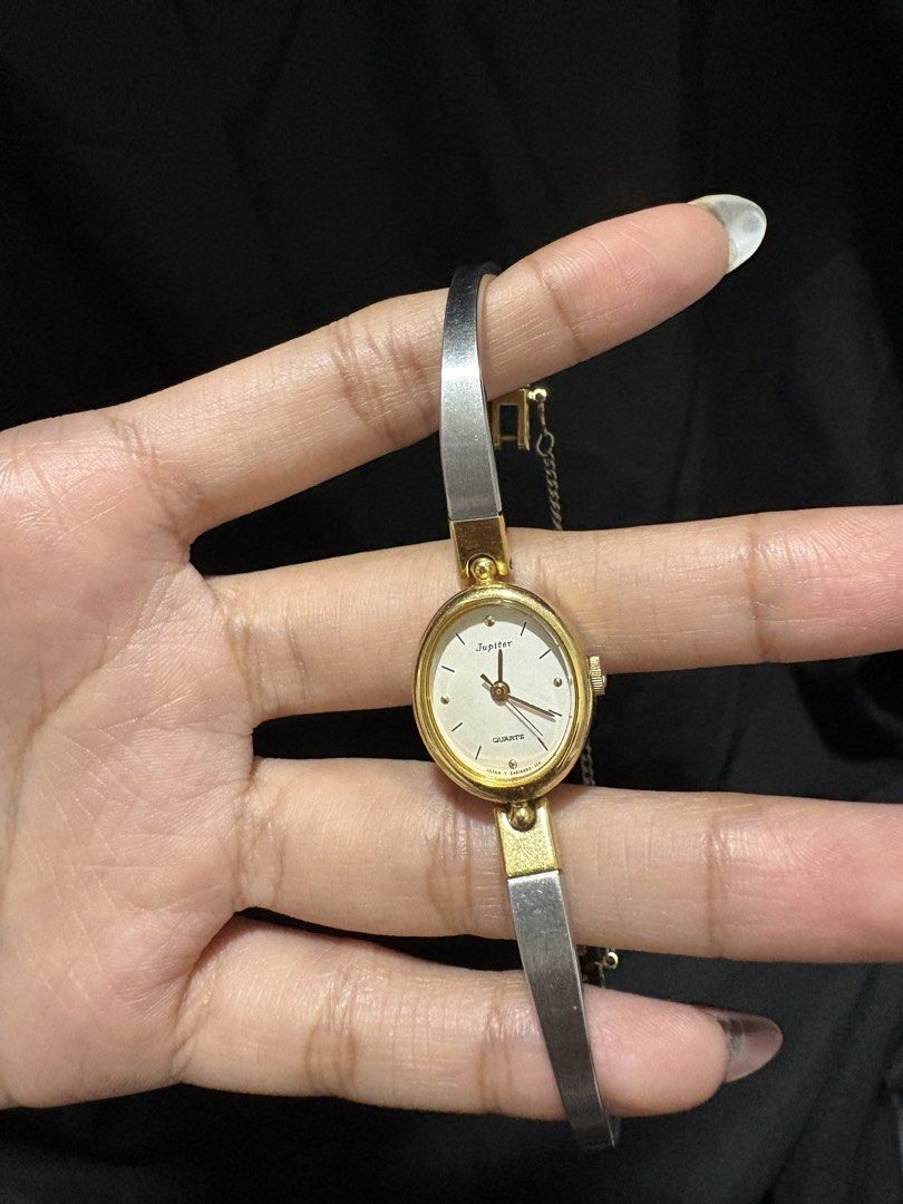 Orient Jupiter Quartz Oval Bangle Watch Two-Tone (Category: Women's Watches) located in Caloocan City. Submitted by esnairahhh (Listing ID 1465378316, Image 1). Description: - Brand/Model: Jupiter oval face wristwatch - Band: Two-tone metal bracelet in silver and gold - Dial: White face with dark baton markers and hands - Movement: Classic quartz movement (marked Japan) - Features: Right-side crown for time adjustment and a secure safety chain ne