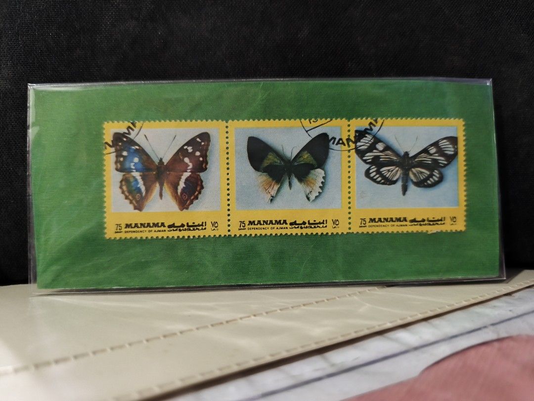 Vintage Postage Stamps Collection (Category: Stamps & Prints) located in Paranaque City. Submitted by heyitsmeaj (Listing ID 1465244304, Image 1). Description: - Collection of vintage postage stamps and souvenir items - Features Manama butterfly stamps, Ajman art stamp, Singapore commemorative sets, Romania Los Angeles 84 sports stamps, and a Sacred Heart souvenir album - Stored securely in protective sleeves - Perfect for stamp collectors and to