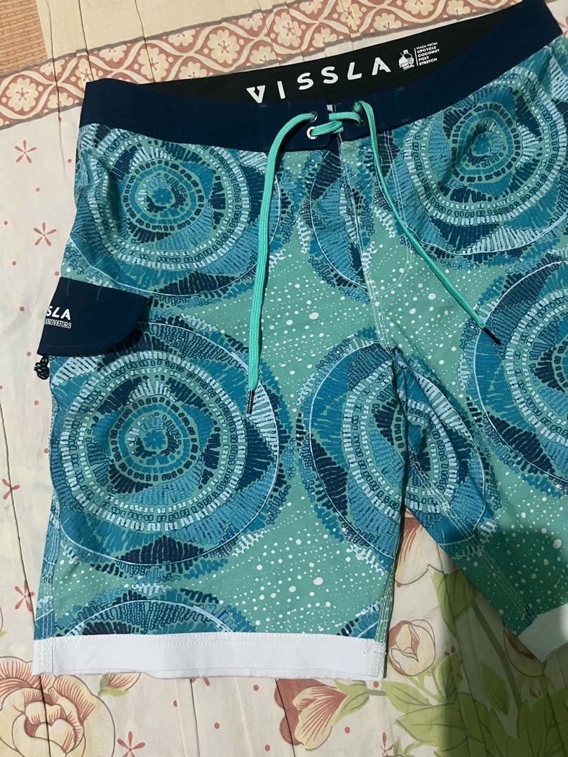 Vissla Teal Blue Patterned Board Shorts (Category: Swim Trunks & Board Shorts) located in Calamba. Submitted by summercollectionph (Listing ID 1465312497, Image 3). Description: Vissla board shorts in teal and dark blue with circular patterns. Turquoise drawstring at the waist, solid dark waistband, small side pocket on the right leg. White accent panels at the bottom hems. Made from upcycled coconut poly stretch fabric. Lightweight material, goo