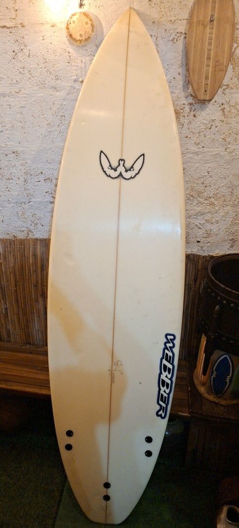 Webber 6'1 Surfboard (Category: Water Sports) located in Manila. Submitted by glydelmalu86312 (Listing ID 1465308973, Image 2). Description: - Brand/Model: Webber Surfboard - Size: 6'1 with a classic shape - Setup: Six-plug setup on the bottom, traction pad at the tail - Aesthetics: Red gradient nose spray and authentic stickers (Aleeda, Bouche) - Condition: Yellowing and pressure dents from regular use, 100% water-ready.