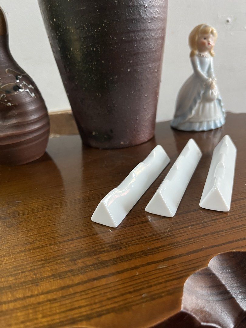 White ceramic chopstick rests set of three (Category: Dinnerware & Cutlery) located in Taguig. Submitted by minmin_parker (Listing ID 1465230302, Image 3). Description: - Set of 3 minimalist white ceramic chopstick rests - Unique triangular prism shape with a recessed channel to keep chopsticks secure - Clean, glossy glaze finish - Perfect Japanese dining table accessories - Condition: Great, clean with no chips or cracks - Selling as a set.