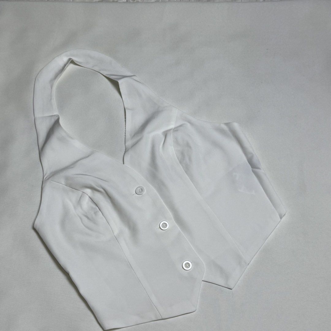 White Halter Neck Vest Top with Buttons (Category: Sleeveless) located in Santa Rosa. Submitted by kym_11 (Listing ID 1465334363, Image 1). Description: - Color: White - Style: Halter neck, cropped fit, structured collar, and open back - Details: Three matching front buttons - Material: Smooth and lightweight - Condition: Clean overall - Pairing: Perfect with high-waisted jeans or skirts.