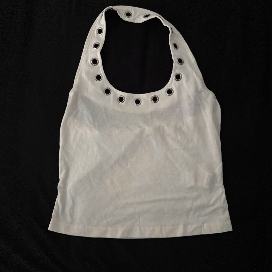 White Halter Top with Metal Grommets (Category: Sleeveless) located in Manila. Submitted by jhoysfabcloset (Listing ID 1465235465, Image 1). Description: - Color: White - Material: Soft, breathable cotton - Style: Sleeveless halter top with cropped fit - Details: Silver-toned metal grommets around the neckline and straps - Pairing: Looks great with denim jeans or skirts - Condition: Brand new / Excellent quality.