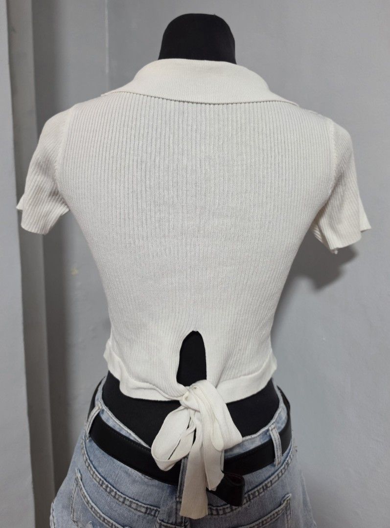 White Knitted Crop Top with Collar and Back Tie (Category: Blouses) located in Paranaque City. Submitted by franinnashop (Listing ID 1465310494, Image 2). Description: DECLUTTER SMALL TO MED PARANAQUE CITY - White ribbed knit crop top - V-neck collar with short sleeves - Back keyhole opening with tie-up ribbon detail - Stretchy and lightweight material - Flaw note: Small brownish spot on right collar and faint yellow stain on back tie strap.