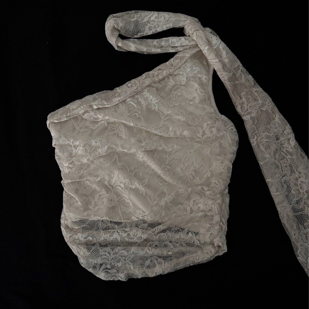 White Lace One-Shoulder Halter Top (Category: Sleeveless) located in Manila. Submitted by jhoysfabcloset (Listing ID 1465236635, Image 1). Description: - Style: White lace one-shoulder top with asymmetric neckline - Detail: Features an all-over floral lace pattern and a matching neck tie strap - Versatility: Pairs effortlessly with a black skirt for chic evening outings - Condition: Brand new / Excellent (ready to wear) - Mode of Payment: GCash, 