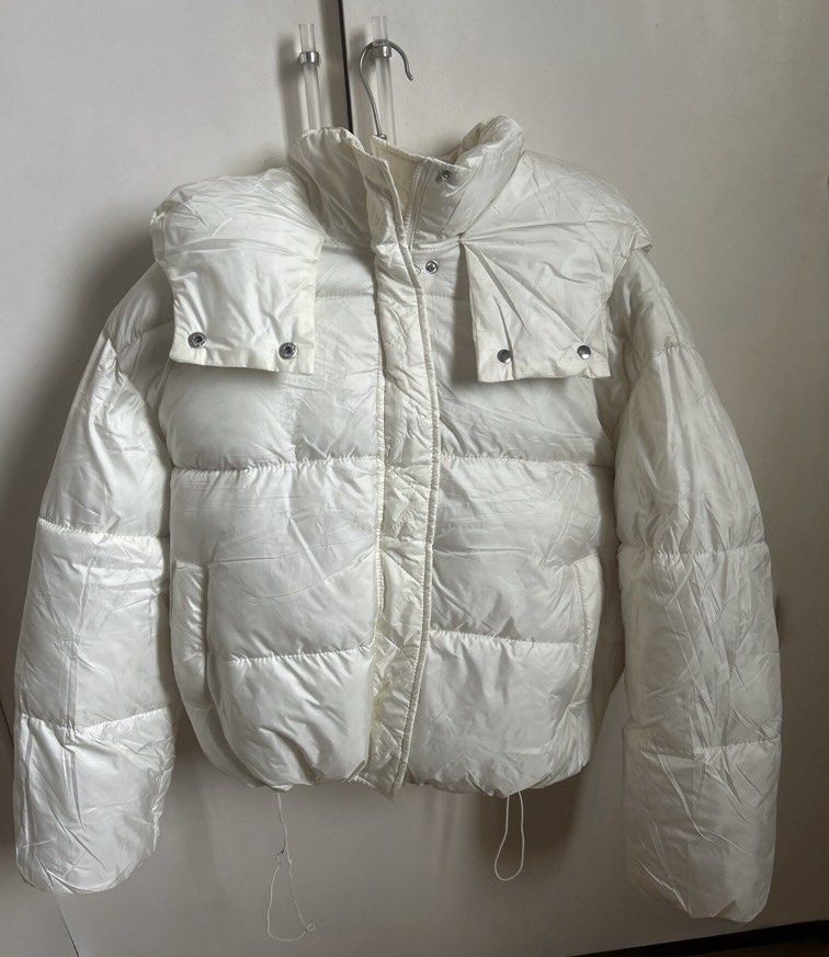 White puffy winter jacket with large hood (Category: Coats, Jackets and Outerwear) located in Manila. Submitted by randomstuffiown (Listing ID 1465350523, Image 1). Description: - Color: Off-White - Super cozy quilted padding, perfect for cold days - Big oversized hood to block the wind - Dual closure: Front zipper and snap buttons - Adjustable drawstrings at the hem - Convenient pockets on both sides - Soft material, easy to layer over sweaters.
