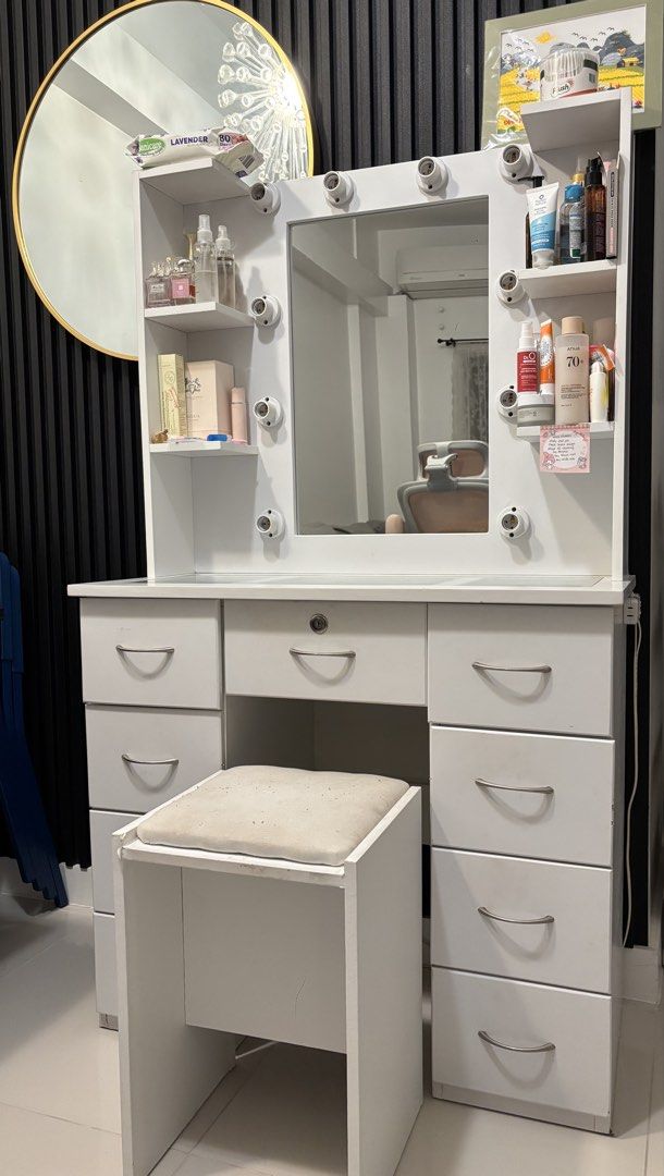 White Vanity Makeup Table with Hollywood Lights and Stool (Category: Tables & Sets) located in Taguig. Submitted by mommae_preloved (Listing ID 1465338166, Image 1). Description: *Items not included! Slightly Nego RFS: Decluttering to make more space in our home Pick up in our home or delivery - Color: White with glass-top middle drawers for easy viewing - Lighting: Built-in Hollywood light sockets around the mirror - Seating: Includes a comforta