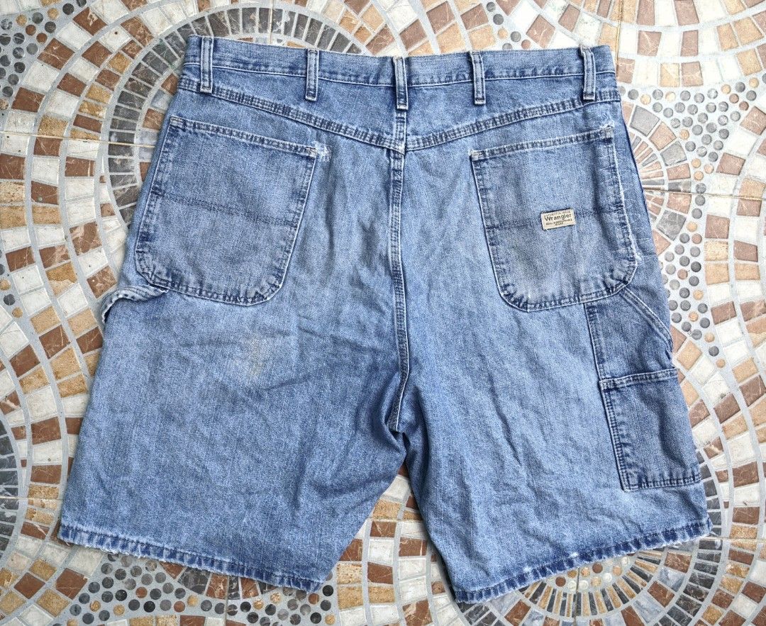 Wrangler Carpenter Denim Shorts Size 38 (Category: Shorts) located in Quezon. Submitted by miksxthrift (Listing ID 1465341802, Image 2). Description: - Brand: Wrangler - Style: Carpenter denim shorts - Color/Wash: Light wash blue - Size: Tagged 38 - Material: 100% cotton, Made in Mexico - Closure: Button fly - Features: Multiple utility pockets, left leg hammer loop, iconic woven back pocket label - Condition: Natural fraying and distressed spots