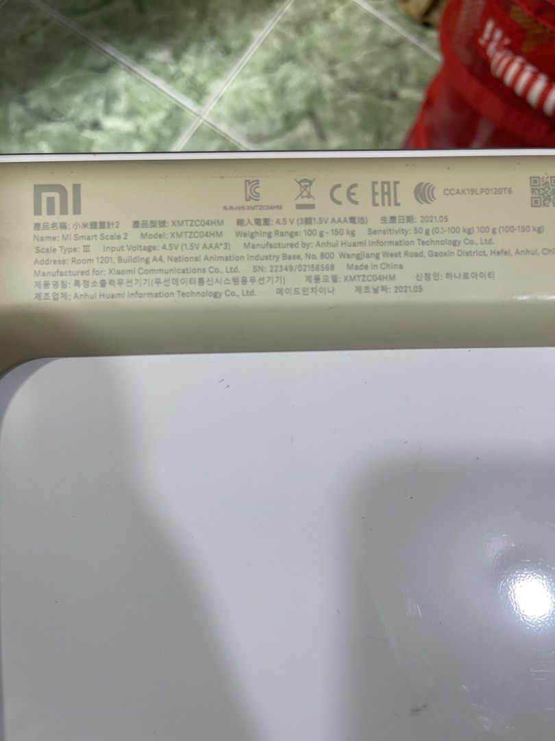 Xiaomi Mi Smart Scale 2 (Category: Health Monitors & Weighing Scales) located in Manila. Submitted by chesterson1979. (Listing ID 1465216124, Image 2). Description: Xiaomi smart scale model XMTZC04HM. White surface with gray Mi logo. Measures up to 150 kg. Requires 3 AAA batteries, currently takes standard Kingever batteries shown in slot. Bottom label lists manufacturing date May 2021. Dimensions measure roughly 28 by 28 centimeters square. Used