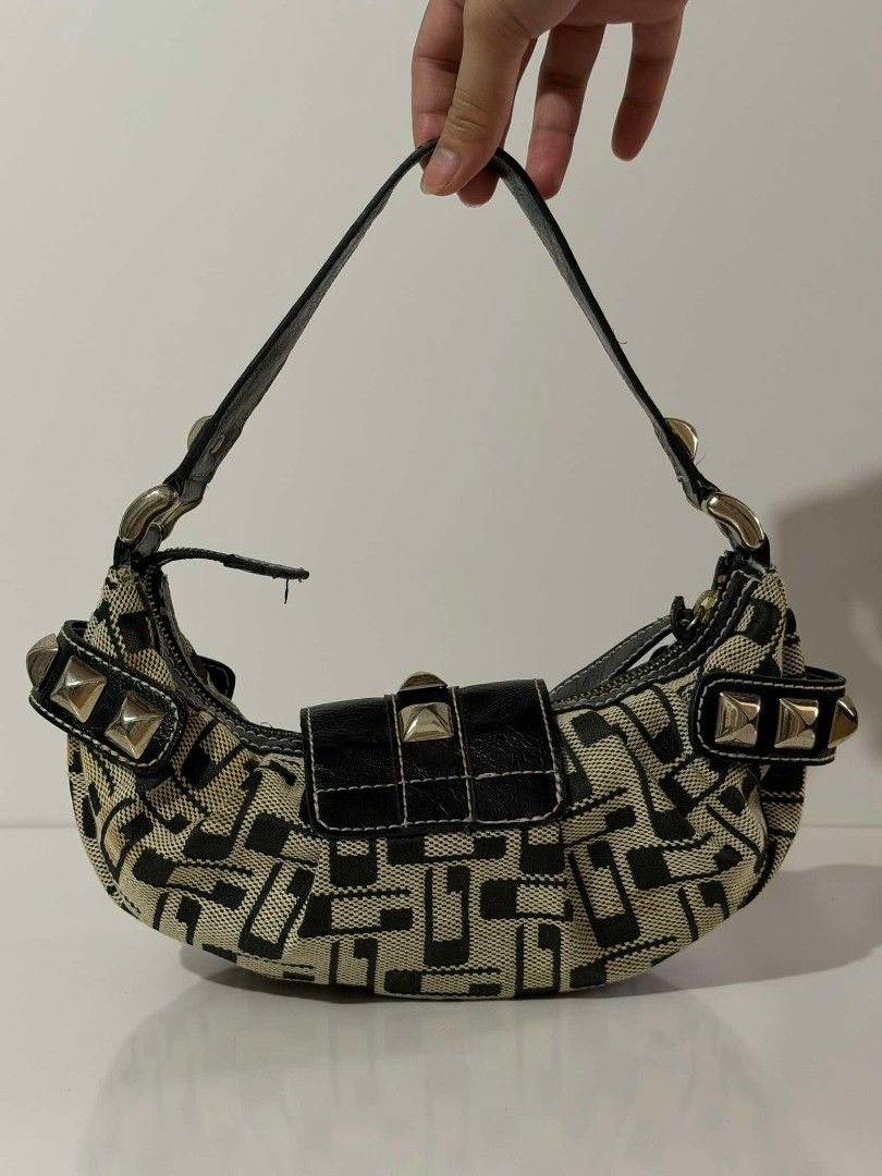 Y2K GUESS MOON SHAPE (Category: Shoulder Bags) located in Manila. Submitted by _louisse (Listing ID 1465354293, Image 2). Description: - Authentic Guess shoulder bag in black and cream monogram canvas - Faux leather trim with chic silver-tone hardware and edgy pyramid studs - Secure front metal lock closure - Trendy leopard print interior lining with a zipped pocket and logo plaque - Comfortable single shoulder strap for easy wear - Condition: Ex