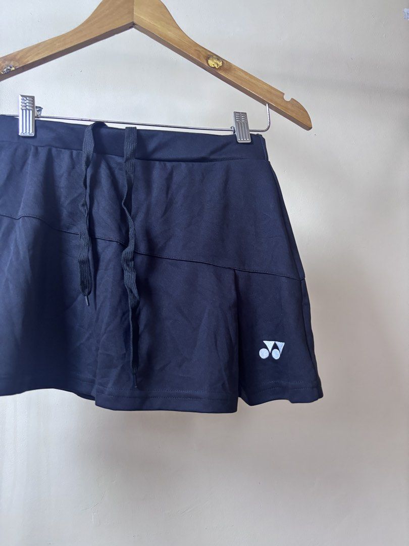 Yonex Black Sports Skort With Drawstring (Category: Activewear) located in Manila. Submitted by galitsabarat (Listing ID 1465260539, Image 2). Description: - Brand: Yonex - Color: Classic black with white logo near the hem - Features: Built-in shorts for coverage and adjustable drawstring waistband - Material: Lightweight and breathable fabric - Best for: Tennis, badminton, running, and workouts - Measurements: 15 inches flat waist, 14 inches tot