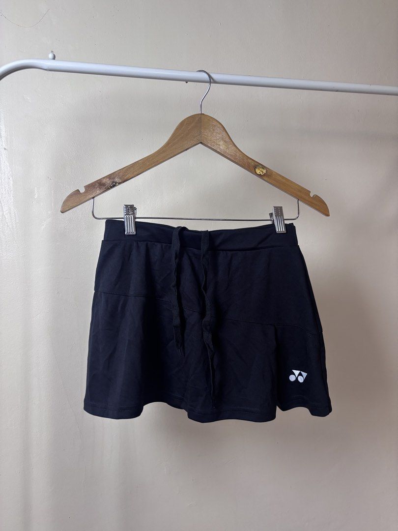Yonex Black Sports Skort With Drawstring (Category: Activewear) located in Manila. Submitted by galitsabarat (Listing ID 1465260539, Image 1). Description: - Brand: Yonex - Color: Classic black with white logo near the hem - Features: Built-in shorts for coverage and adjustable drawstring waistband - Material: Lightweight and breathable fabric - Best for: Tennis, badminton, running, and workouts - Measurements: 15 inches flat waist, 14 inches tot