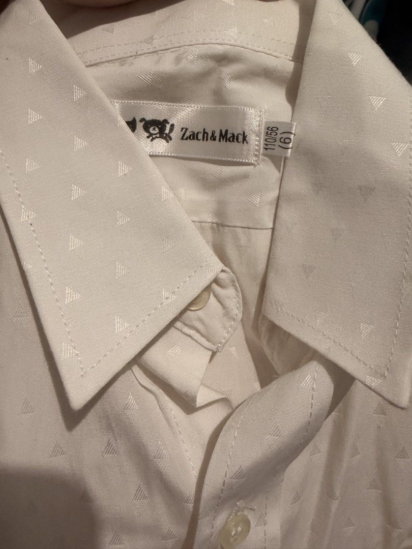 Zach & Mack White Patterned Long Sleeve Shirt Size 6 (Category: Babies & Kids Fashion) located in Las Pinas. Submitted by kleoshop24 (Listing ID 1465210218, Image 2). Description: - Brand: Zach & Mack - Color: White with subtle all-over triangle pattern - Style: Long-sleeve button-down with standard front placket - Details: Left chest pocket, clean collar, and button cuffs - Condition: Excellent, versatile staple piece - Occasion: Ideal for schoo