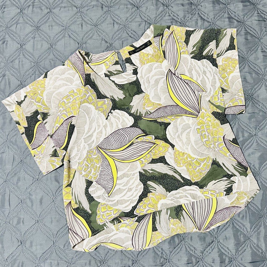 Zara Basic Floral Print Short Sleeve Blouse Size S (Category: Blouses) located in Quezon City. Submitted by halfofit (Listing ID 1465190160, Image 1). Description: - Brand: Zara Basic - Size: S - Color/Pattern: Green background with white, yellow, and purple abstract floral print - Design: Short sleeves, square neckline, back keyhole cutout with button closure - Material: Lightweight fabric - Origin: Made in Turkey - Styling: Easy to pair with je
