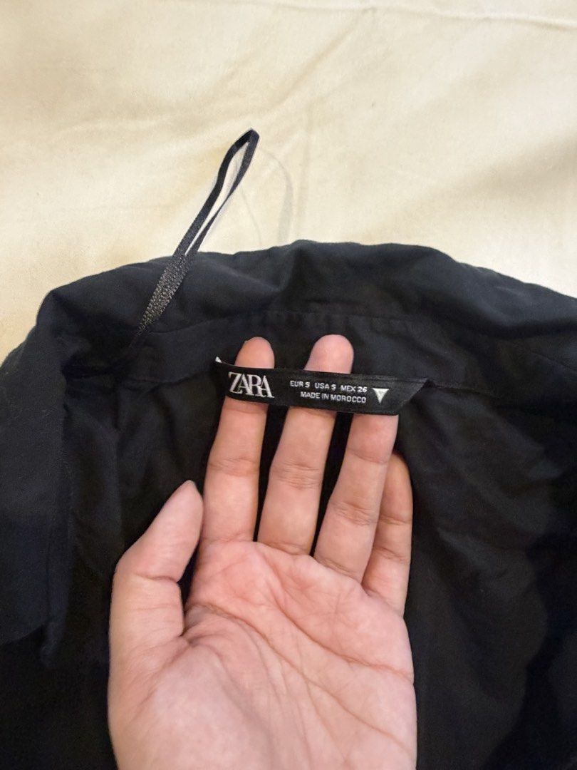 Zara Black Button-Up Shirt Size S (Category: Shirts) located in Quezon City. Submitted by takemythingz (Listing ID 1465215771, Image 2). Description: - Brand: Zara - Size: S (Made in Morocco) - Color: Classic Black - Design: Short puff sleeves with gathered cuffs, classic collar, and front button closure - Details: Pleated upper back and curved, high-low hem - Material: Lightweight fabric, perfect for layering or wearing solo - Condition: Excelle