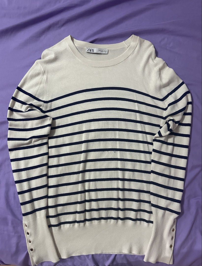 Zara Striped Knit Sweater Size L (Category: Longsleeves) located in Quezon City. Submitted by renzo__01 (Listing ID 1465239303, Image 1). Description: - Brand: Zara - Color: Off-white with dark blue horizontal stripes - Neckline: Classic crew neck - Details: Chic small gold-toned buttons on long sleeve cuffs - Finish: Ribbed trim at hem and cuffs - Material: Soft and comfortable, ideal for casual daily styling.