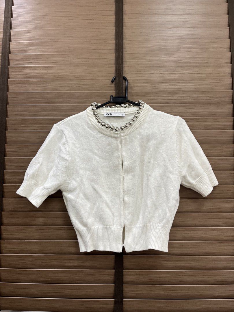 Zara White Cardigan With Silver Beads Size M (Category: Coats, Jackets and Outerwear) located in Mabalacat. Submitted by fashionclothesph (Listing ID 1465307398, Image 1). Description: - Brand: Zara - Size: M (tag attached) - Color: White - Style: Short-sleeve knit cardigan with silver metallic ball neckline embellishments - Details: Ribbed cuffs and hem - Material: 55% viscose, 25% polyester, 20% polyamide.
