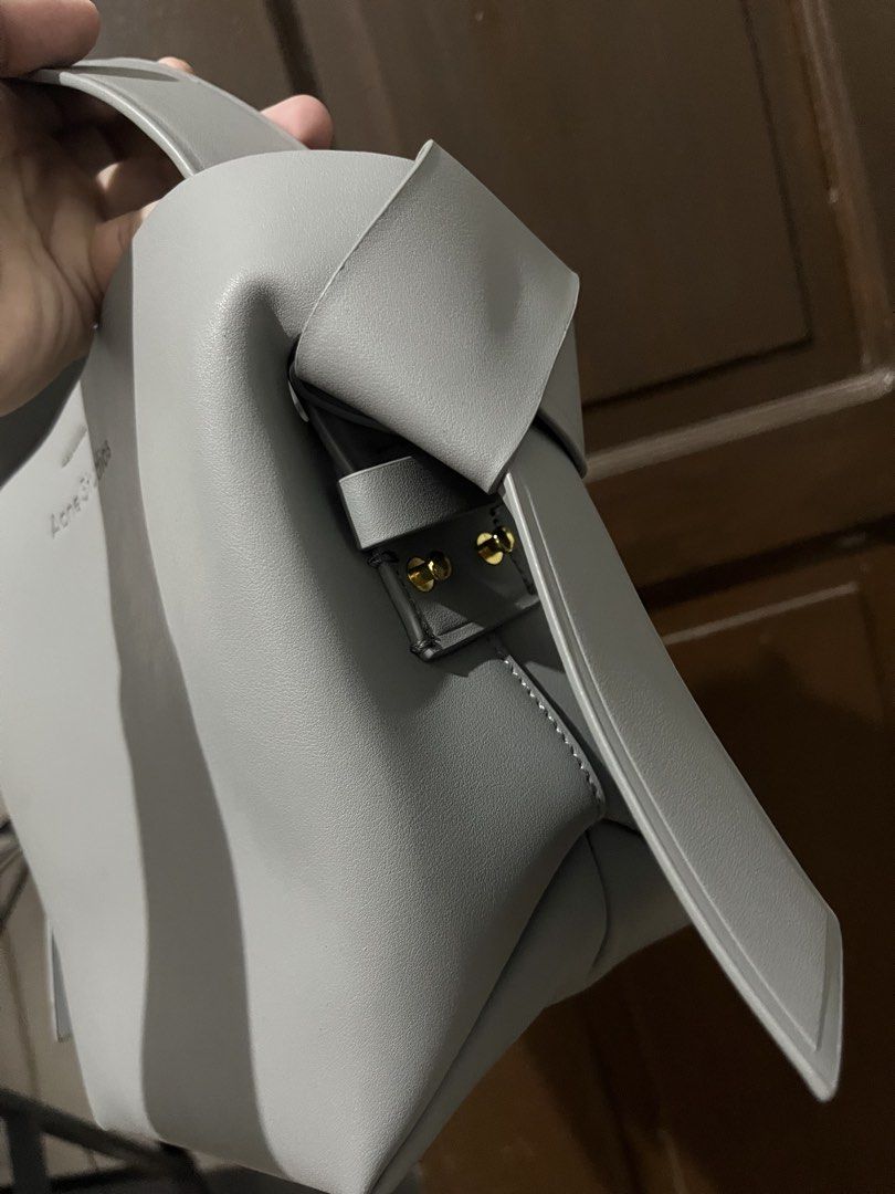 Acne Studios Grey Musubi Mini Bag (Category: Luxury Bags & Wallets) located in Mabalacat. Submitted by onlygrail.pamp (Listing ID 1467143030, Image 3). Description: - Brand: Acne Studios - Color: Grey - Material: Premium Leather - Condition: Barely any signs of wear (Pristine) - Hardware: Gold-tone with signature studs - Exterior: Clean front debossed logo lettering & signature knotted sides - Interior: Center zippered compartment divider and sna