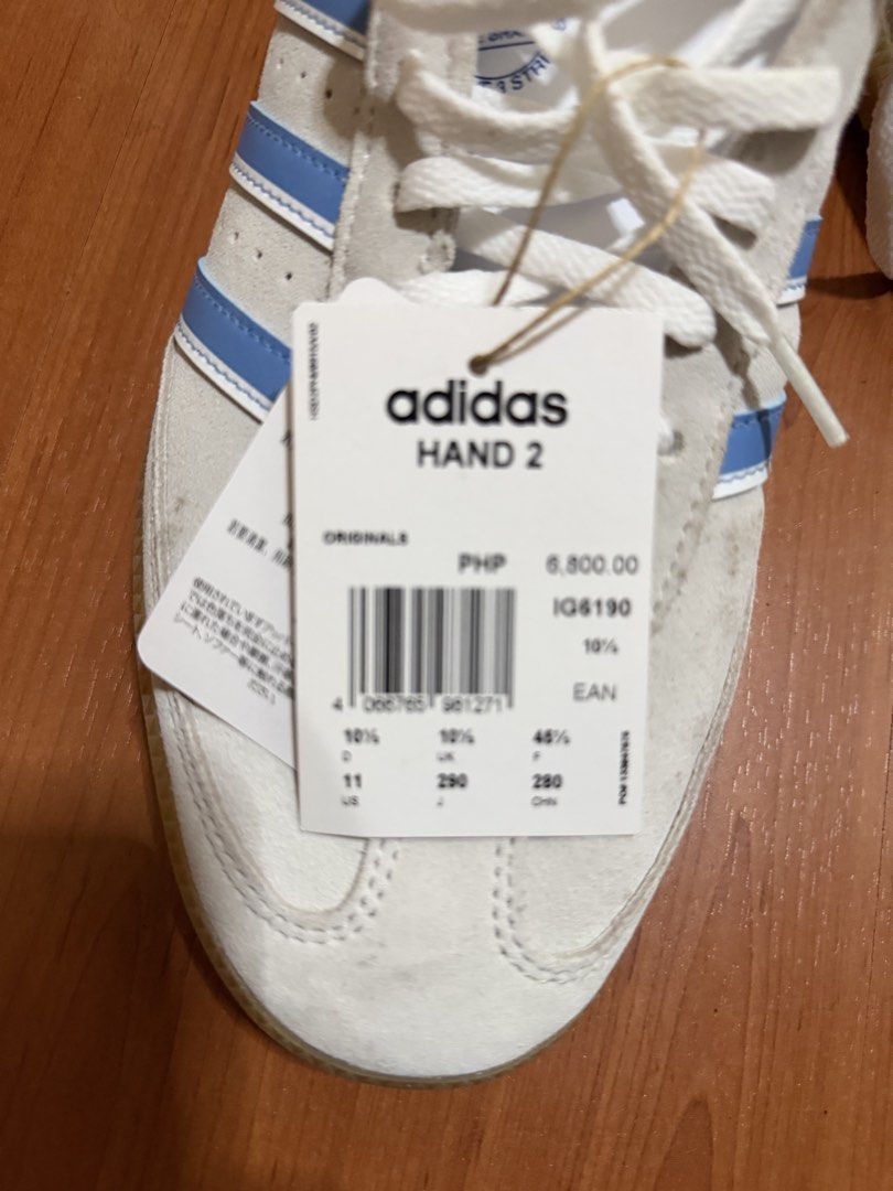 Adidas Hand 2 White Blue Sneakers (Category: Sneakers) located in Batangas. Submitted by bullet909 (Listing ID 1467134943, Image 3). Description: - Brand: Adidas - Model: Hand 2 - Colorway: White with light blue stripes and gum soles - Size: UK 10.5 / US 11 - Condition: Brand new with original store tag attached - Features: Classic low-top design, premium suede texture, and contrast tongue branding - Mode of transaction: Shipping or meet-ups avai