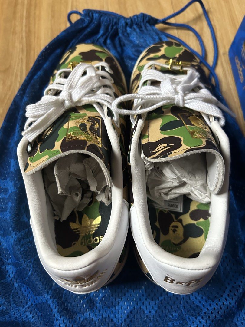 Adidas x Bape Stan Smith Sneakers Authentic (Category: Sneakers) located in Cavite. Submitted by zacharyyy__ (Listing ID 1467065505, Image 3). Description: - Brand: Adidas Stan Smith x A Bathing Ape (BAPE) - Colorway: Green Camouflage with gold foil branding - Size: US 7 / UK 6.5 / FR 40 - Accessories: Gold ape head lace locks, blue camo dust bag, and original blue camo box included - Condition: Clean uppers, crisp shape, with original paper stuf