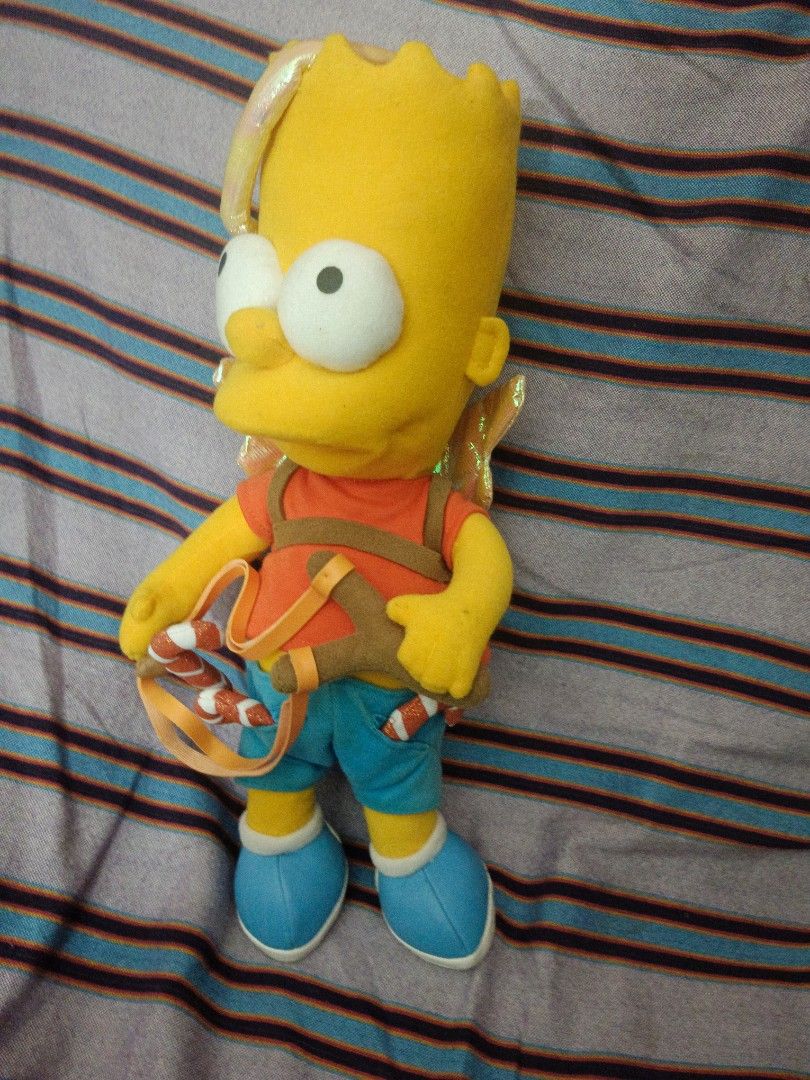 Applause 2004 Bart Simpson Cupid Angel Plush Toy (Category: Plushies & Soft Toys) located in Baguio. Submitted by adulagan1998258 (Listing ID 1467084018, Image 2). Description: - Rare 1979-2004 Applause 25th Anniversary Edition Bart Simpson Cupid plush - Features shiny golden wings, a halo, and a slingshot holding candy canes - Classic outfit: orange shirt, blue shorts, and blue sneakers - Original Applause tag attached on the wing - Great additi