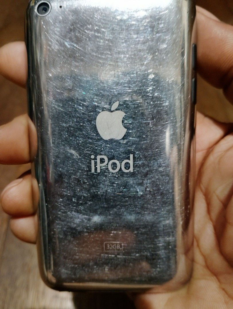Apple iPod touch 32GB (Category: Portable Music Players) located in Manila. Submitted by boyhet.thrift15 (Listing ID 1467110153, Image 2). Description: Apple iPod touch, 32GB storage capacity. Classic model with home button below the display and 30-pin dock connector on the bottom. Chrome back shows heavy scuffs and scratches from regular use. Charges and syncs through the standard port. Headphone jack on the bottom edge. Great vintage music play