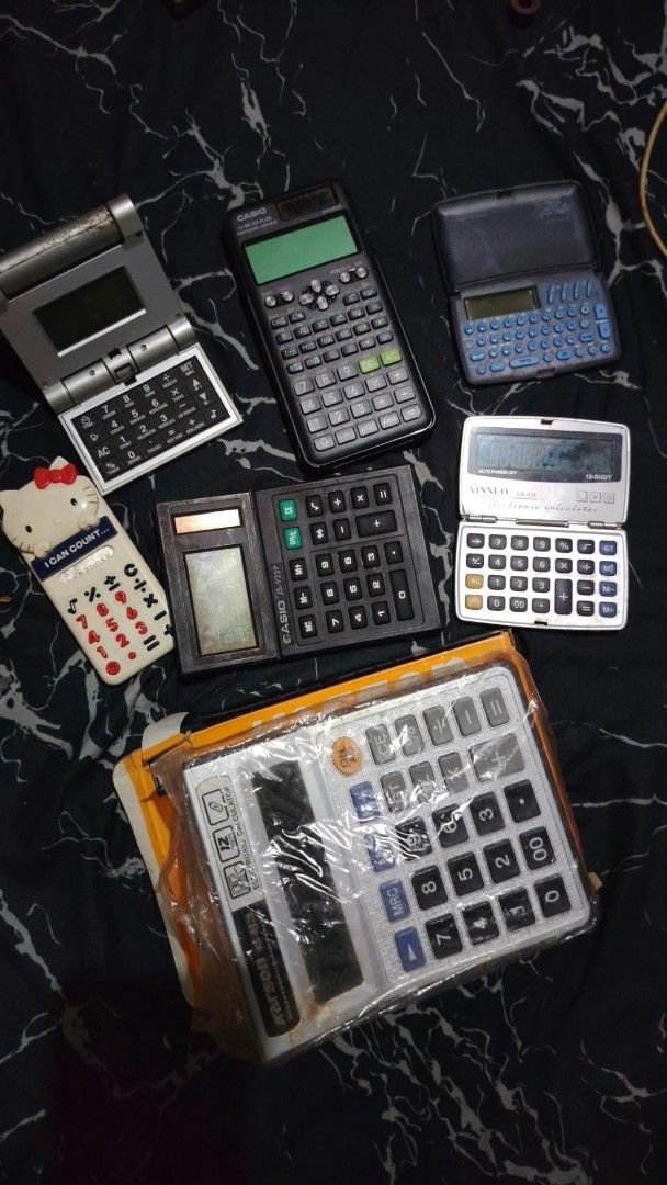 Assorted Vintage and Modern Calculators Lot (Category: Stationery & School Supplies) located in Caloocan City. Submitted by chuaniki (Listing ID 1467154663, Image 1). Description: - Calculator bundle featuring various brands, colors, and styles - Includes Casio scientific, Kitty novelty, folding pockets, desktop units, and a brand new boxed Karson - Condition ranges from used with age wear to brand new and sealed in original packaging - Perfect f