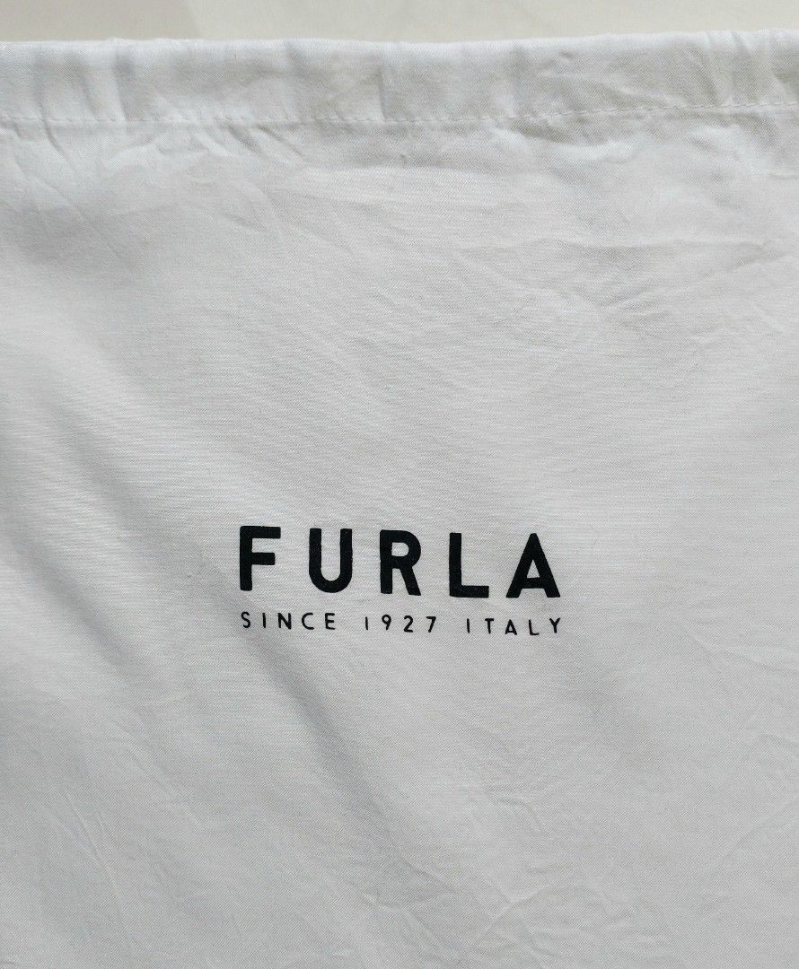 Authentic Furla white dust bag drawstring pouch (Category: Luxury Bags & Wallets) located in Lapu Lapu. Submitted by agnesapm_29813 (Listing ID 1467107062, Image 2). Description: - Authentic Furla white dust bag - Black printed logo: "Furla Since 1927 Italy" - Convenient single drawstring closure on the side - Dimensions: Roughly 11.5" x 10" - Ideal for protecting your luxury bags and accessories from dust.