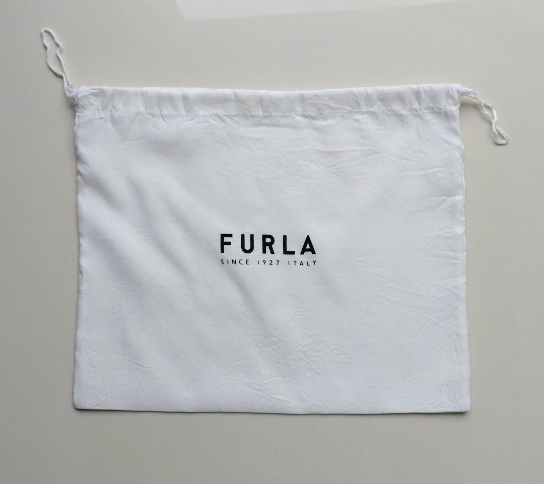 Authentic Furla white dust bag drawstring pouch (Category: Luxury Bags & Wallets) located in Lapu Lapu. Submitted by agnesapm_29813 (Listing ID 1467107062, Image 1). Description: - Authentic Furla white dust bag - Black printed logo: "Furla Since 1927 Italy" - Convenient single drawstring closure on the side - Dimensions: Roughly 11.5" x 10" - Ideal for protecting your luxury bags and accessories from dust.