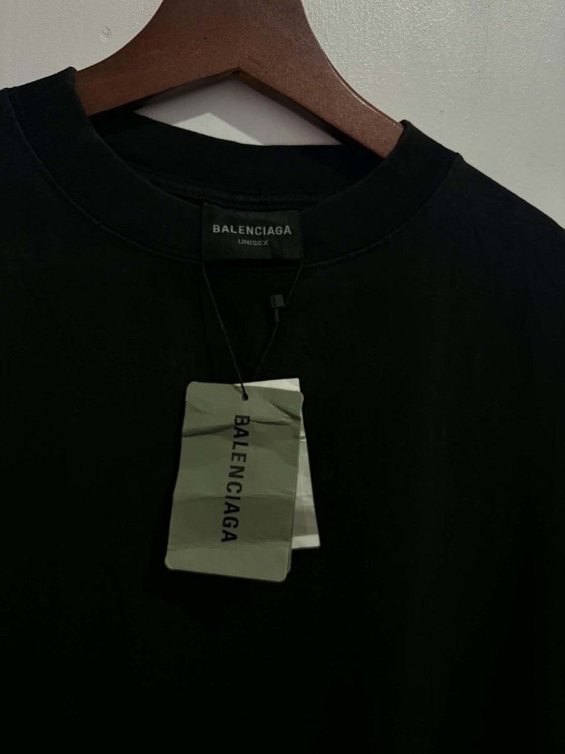 Balenciaga Metal Logo Black Tee (Category: Shirts) located in Daraga. Submitted by argarinang25024 (Listing ID 1467032468, Image 3). Description: - A Balenciaga black t-shirt brand new with hangtags - Bold metallic arched graphic on the back - Premium heavy cotton fabric with oversized fit - Classic ribbed crew neckline - Brand new with original store tags attached - Inner wash label features clear product codes for authenticity - need wash fresh