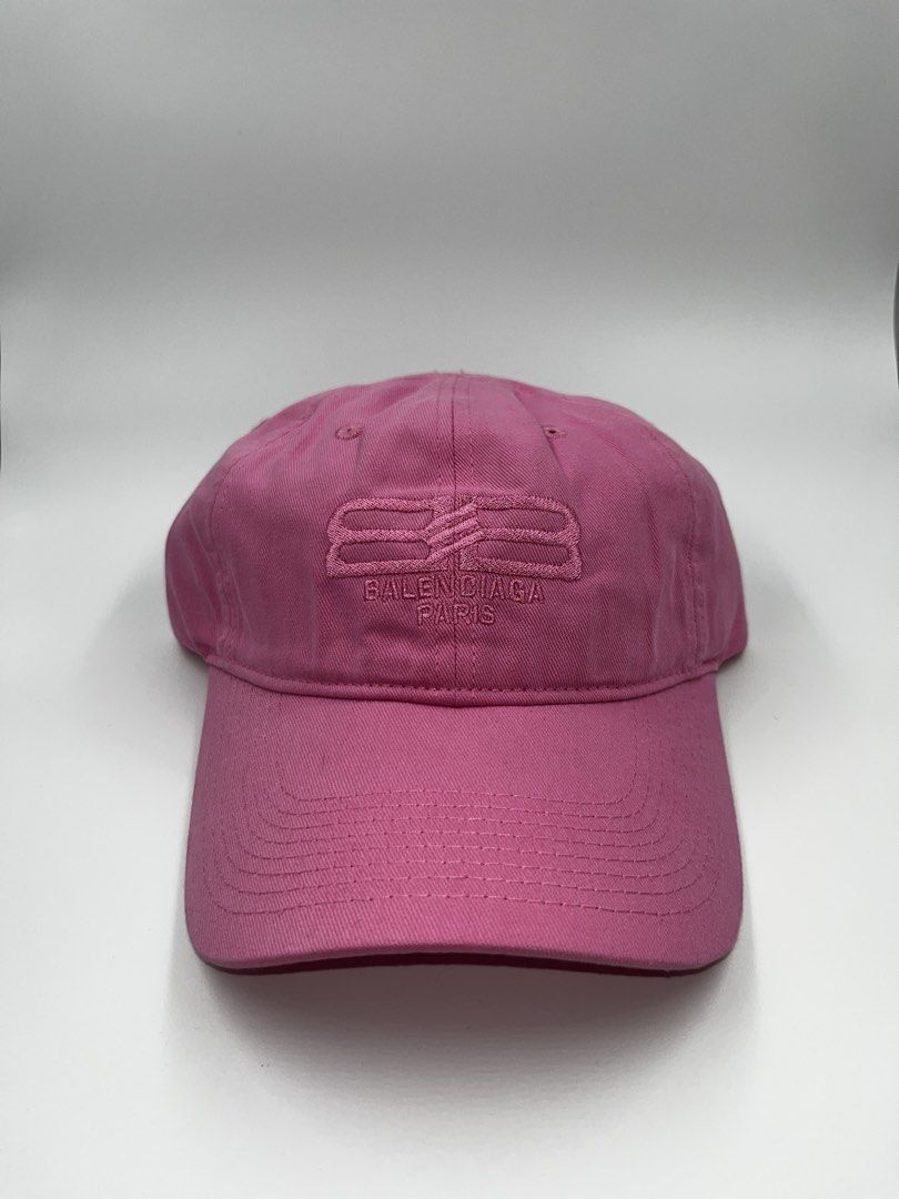 Balenciaga Paris BB Logo Pink (Category: Caps & Hats) located in Manila. Submitted by five_gallery (Listing ID 1467167210, Image 1). Description: - Brand: Balenciaga Paris - Color: Bright Pink - Material: 100% Cotton - Design: Embroidered BB logo on front with tonal pink stitching - Details: Curved brim with multi-row stitching, top ventilation eyelets - Fit: Adjustable strap at the back for a custom fit - Style: Ideal for casual streetwear and a