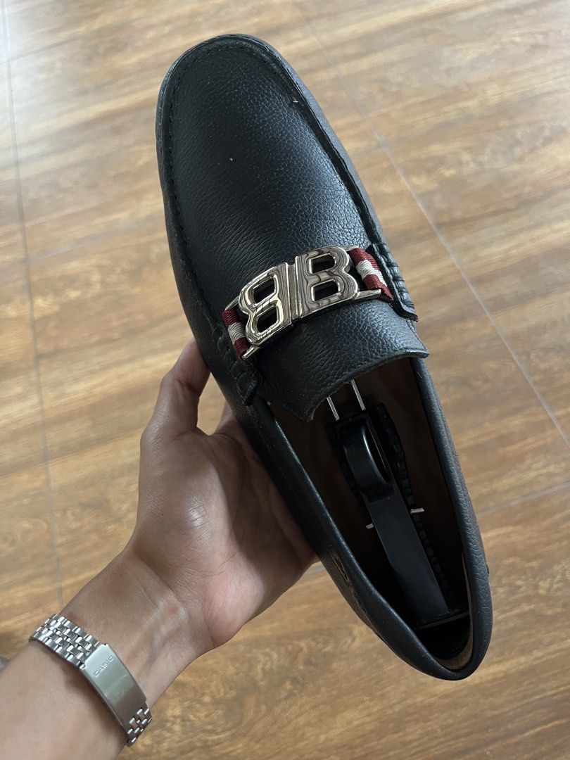 Bally Black Leather Loafers (Category: Casual Shoes) located in Paranaque City. Submitted by alasthrift26 (Listing ID 1467050257, Image 3). Description: - Brand: Bally - Style: Slip-on loafers - Material: Premium black pebbled leather - Design: Silver metal hardware with signature red and white striped ribbon - Sole: Flexible rubber pebble sole for all-day comfort - Condition: Minimal wear on leather and hardware.