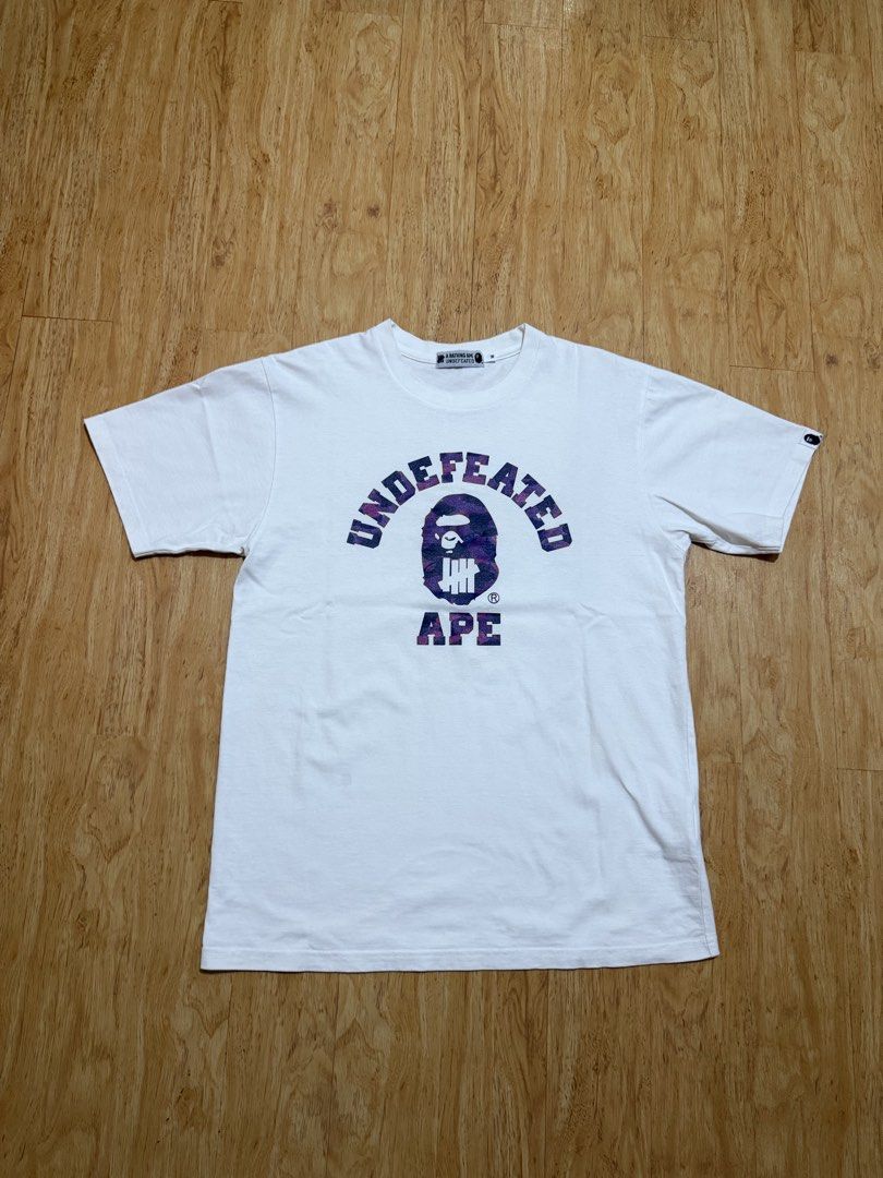 BAPE Undefeated Purple Camo College Tee (Category: Tshirts & Polo Shirts ) located in Danao, Cebu. Submitted by yunoball (Listing ID 1467080233, Image 1). Description: Size M on tag 19.5x27 Condition: excellent Issues: none Guaranteed authentic.