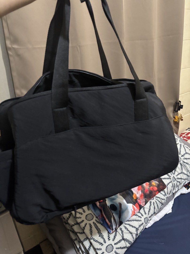 BASH Black Travel Duffle Bag (online photo for reference) (Category: Shoulder Bags) located in Muntinlupa City. Submitted by ashley.18 (Listing ID 1467040787, Image 2). Description: - Brand: BASH - Color: Black - Dimensions: 49cm x 31cm x 17cm - Material: Durable fabric exterior with a spacious interior - Organization: Multiple zipped compartments inside and out - Includes: Detachable blue strap and a Kitty charm on the front handle - Ideal for: 