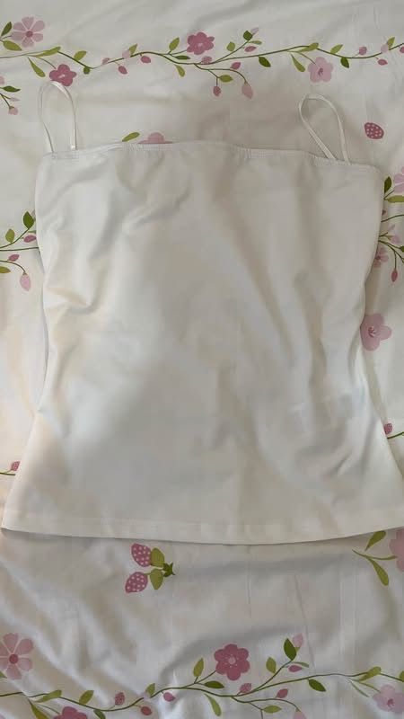 Basic white tube top (Category: Sleeveless) located in Caloocan City. Submitted by lianarchiveee (Listing ID 1467091600, Image 1). Description: - Color: Clean white - Design: Thin spaghetti straps with a flattering straight neckline - Fabric: Soft, stretchy, and comfortable material - Versatility: Perfect for layering under cardigans or wearing solo on hot days - Style: Minimalist and effortless basic.