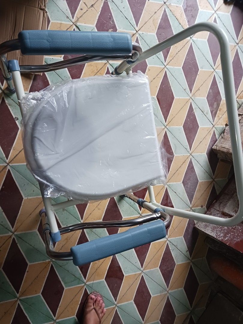 Bedside commode chair with removable pot and padded arms (Category: Medical Supplies & Tools) located in Cebu City. Submitted by joecristinesayson (Listing ID 1466988979, Image 2). Description: - Portable bedside commode chair for elderly and mobility support - Sturdy metal frame with comfortable white seat and blue padded armrests - Includes removable waste bucket with a lid for easy cleaning - Adjustable legs for custom height settings - Essent