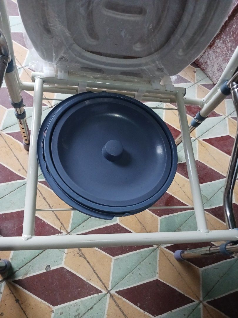 Bedside commode chair with removable pot and padded arms (Category: Medical Supplies & Tools) located in Cebu City. Submitted by joecristinesayson (Listing ID 1466988979, Image 1). Description: - Portable bedside commode chair for elderly and mobility support - Sturdy metal frame with comfortable white seat and blue padded armrests - Includes removable waste bucket with a lid for easy cleaning - Adjustable legs for custom height settings - Essent