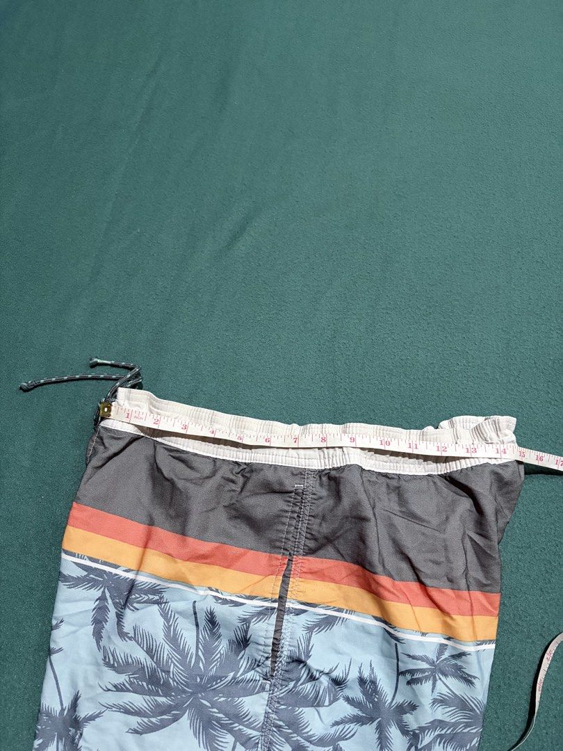 Billabong Tropical Palm Tree Board Shorts (Category: Swim Trunks & Board Shorts) located in Guihulngan. Submitted by fbthriftgoodsniace (Listing ID 1467096172, Image 3). Description: - Brand: Billabong - Design: Grey top section with colorful stripes and palm tree print - Waistband: Elastic with drawstring closure - Features: Single back pocket with velcro flap and brand patch - Measurements: ~16.5 inches across waist, ~17 inches total length - C