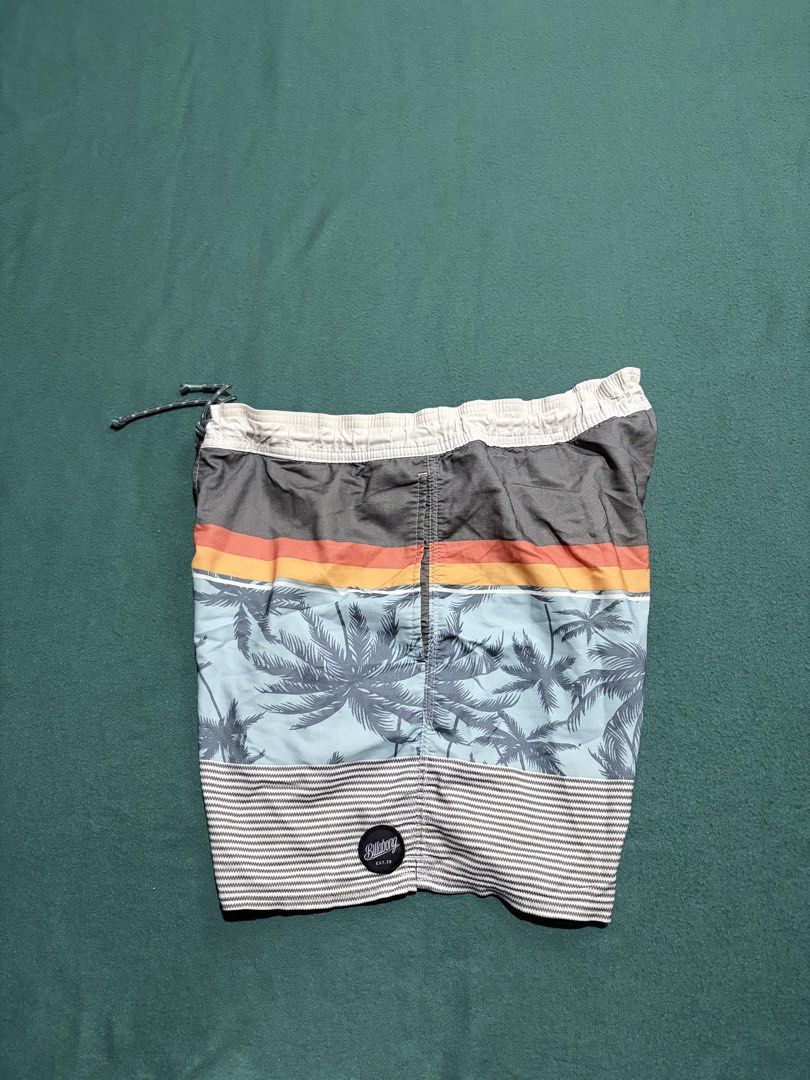 Billabong Tropical Palm Tree Board Shorts (Category: Swim Trunks & Board Shorts) located in Guihulngan. Submitted by fbthriftgoodsniace (Listing ID 1467096172, Image 1). Description: - Brand: Billabong - Design: Grey top section with colorful stripes and palm tree print - Waistband: Elastic with drawstring closure - Features: Single back pocket with velcro flap and brand patch - Measurements: ~16.5 inches across waist, ~17 inches total length - C