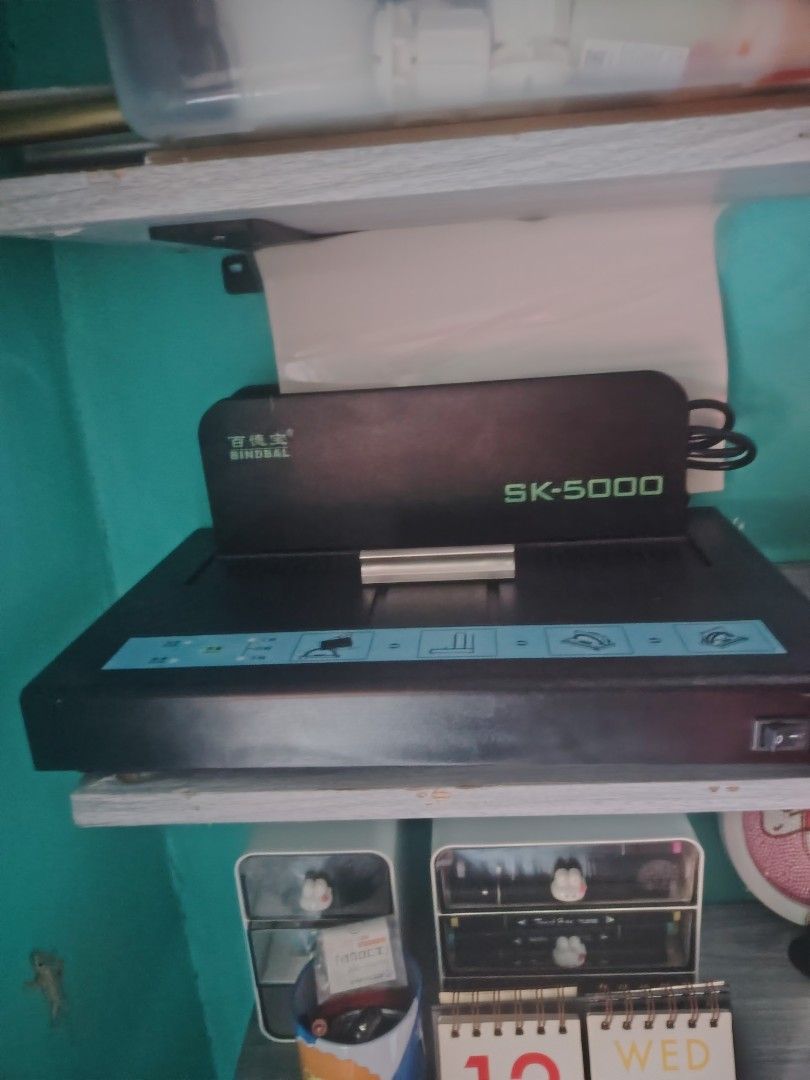 BINDBAL SK-5000 Thermal Binding Machine (Category: Craft Supplies & Tools) located in Taguig. Submitted by benteboy (Listing ID 1466990155, Image 1). Description: - Model: BINDBAL SK-5000 thermal binding machine - Design: Sleek black body with green accents and a blue control strip - Ease of Use: Features simple graphic icons for hassle-free operation - Convenience: Convenient power switch located on the right side - Ideal For: Office reports, st