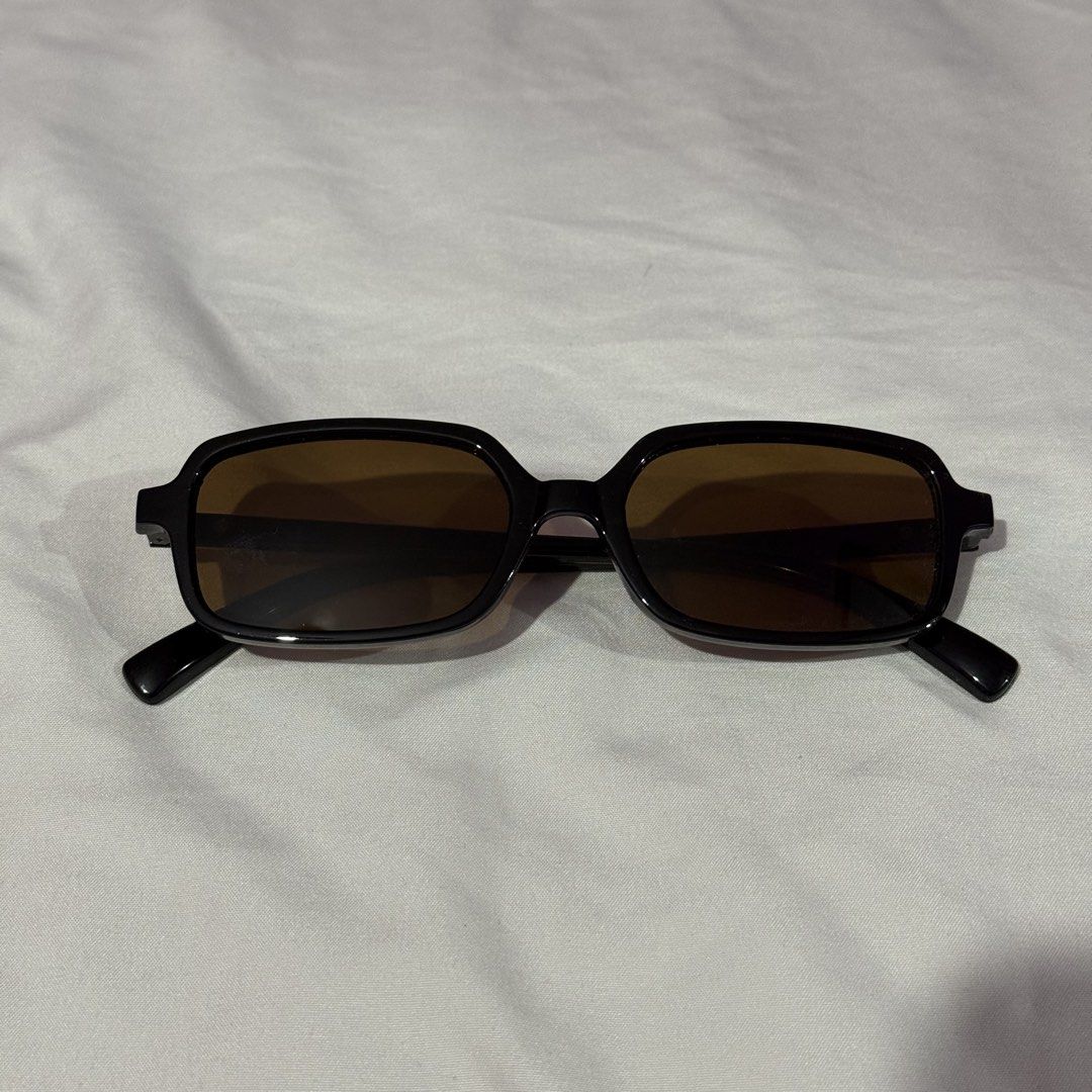 Black and rectangular vintage sunglasses with tinted lenses (Category: Sunglasses & Eyewear) located in Antipolo. Submitted by lykkxv (Listing ID 1467096907, Image 1). Description: - Style: Retro black rectangular frames with minimalist aesthetic - Lenses: Dark brown tinted lenses (a - Details: Chic gold stud hardware accents near the hinges - Features: Lightweight acetate style with foldable arms - Condition: Clean surface, no major scratches - 